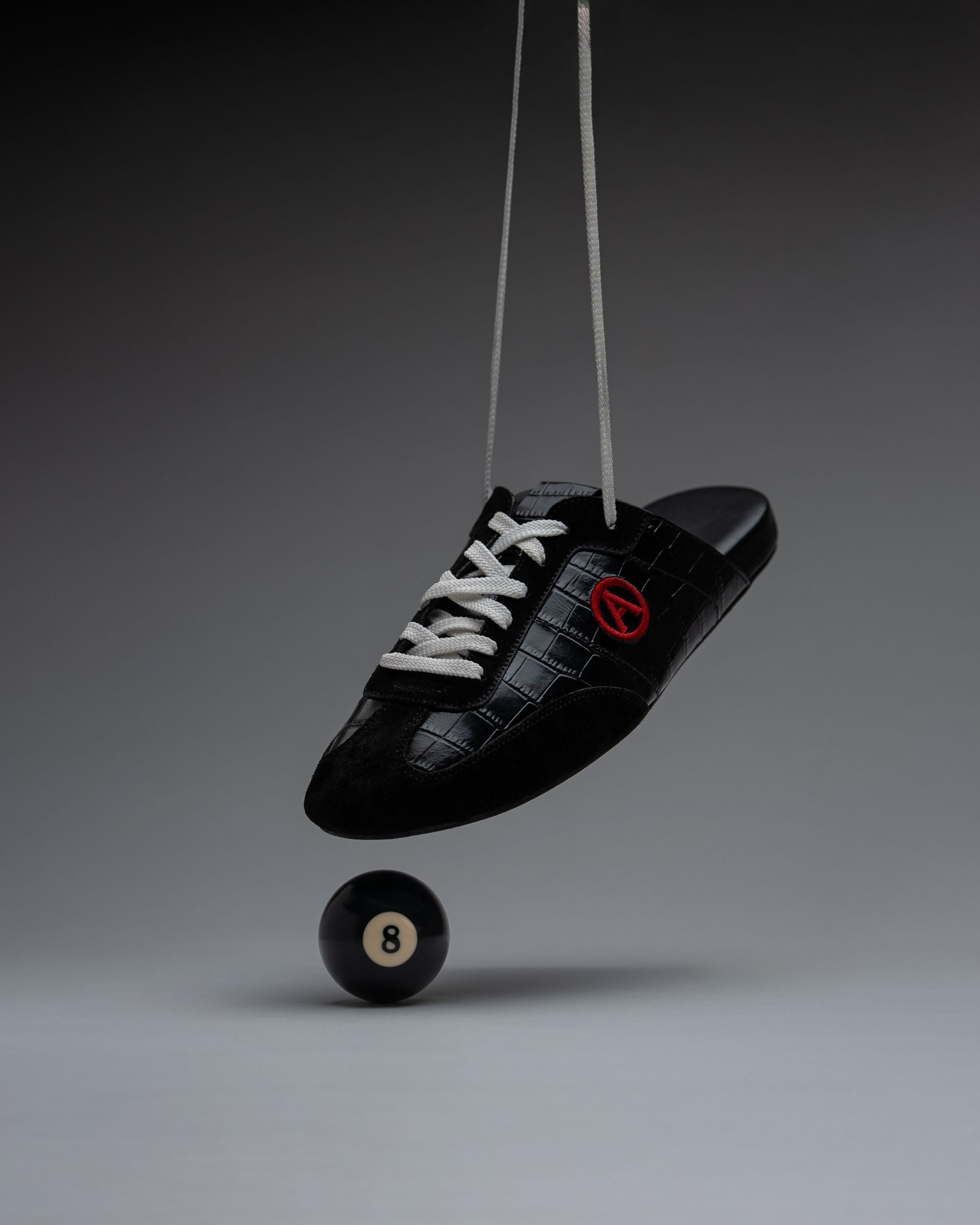 Eko Goose black slide hanging over an eight ball, side profile