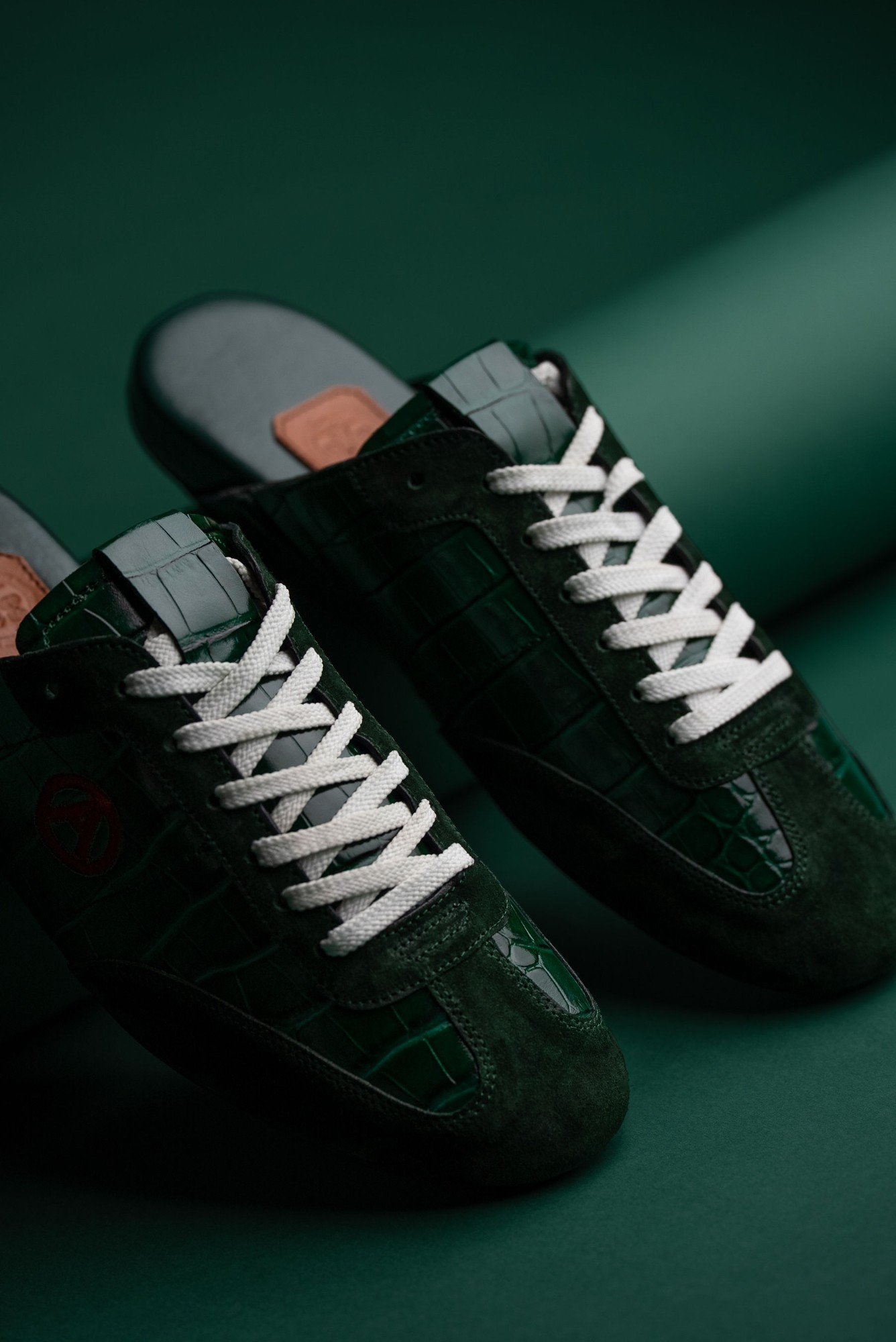 Pair of Eko Goose forest green slides showing white laces and leather insole tab
